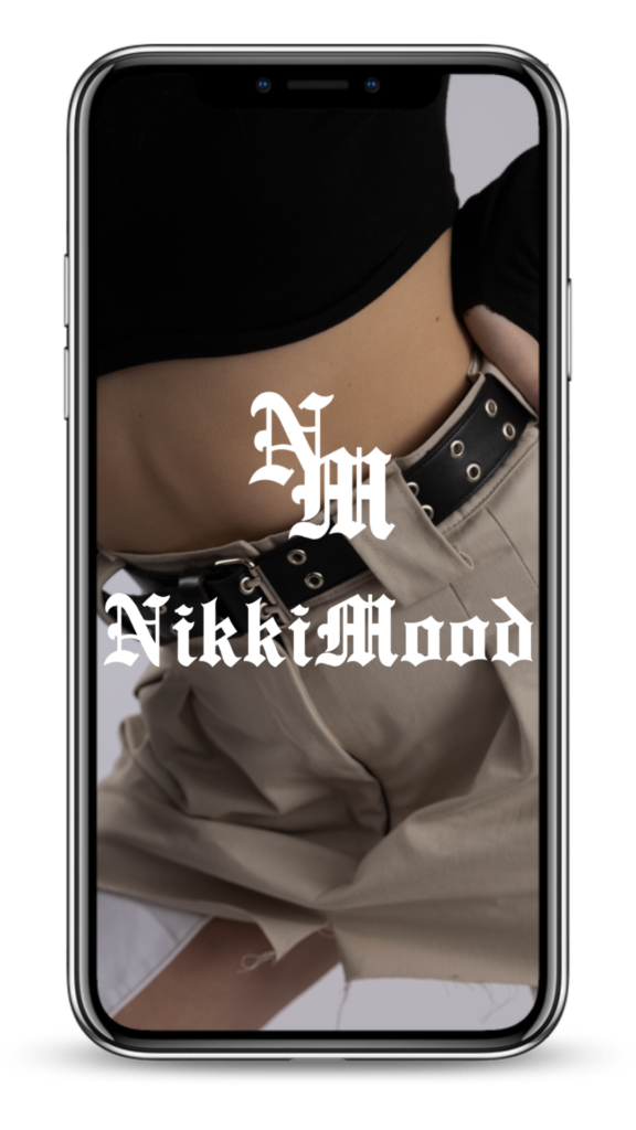 Modelo mostrando parte de un pantalón beige y camiseta negra, con el logo de Nikki Mood superpuesto.
